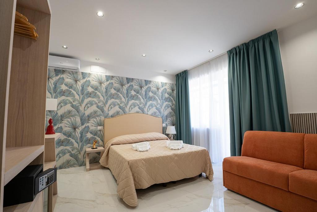 拿坡里的住宿－P.C. Boutique H. LifeStyle, Napoli Centro, by ClaPa Group Dislocated Hospitality，一间卧室配有一张床和一张沙发