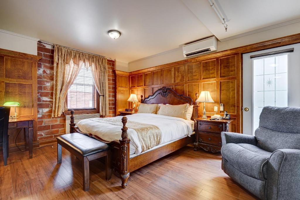 Un dormitorio con una cama, un sofá y una silla. en Le Grand Hôtel, en Baie-Comeau