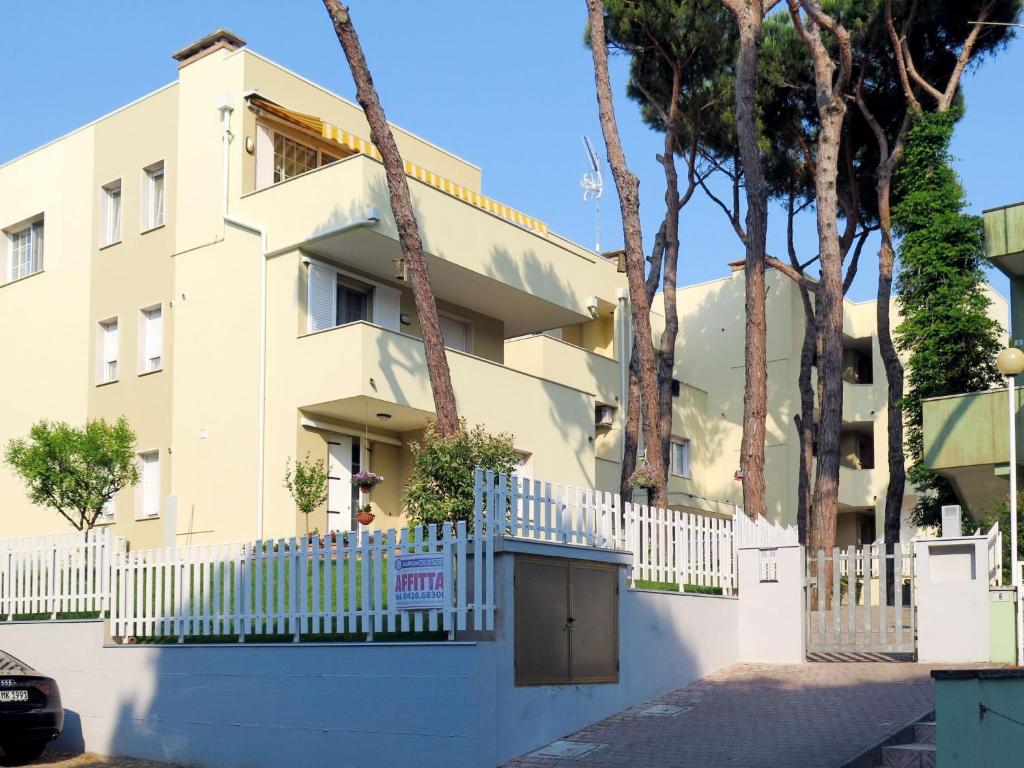 um edifício com uma cerca branca e árvores em Apartment Veranda by Interhome em Rosapineta