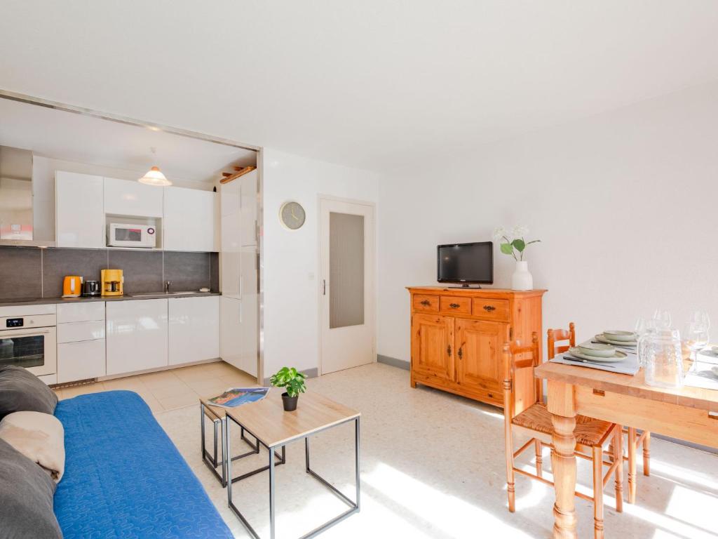 a living room with a blue couch and a table at Apartment Le Grand Large-1 by Interhome in Sainte-Maxime