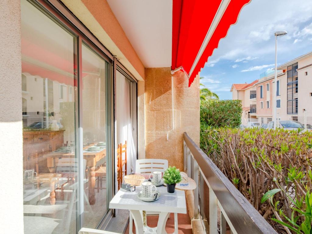 a balcony with a table and a red umbrella at Apartment Le Grand Large-1 by Interhome in Sainte-Maxime