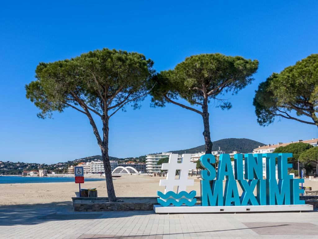 a sign at the beach with trees in the background at Apartment Le Grand Large-1 by Interhome in Sainte-Maxime