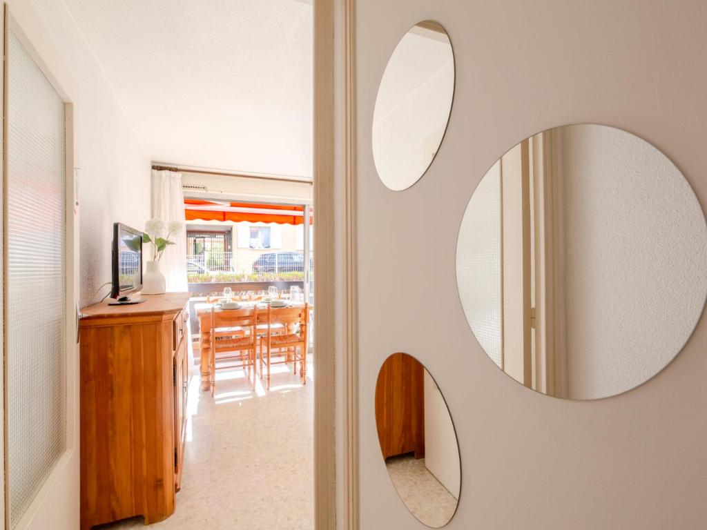 a room with a mirror on the wall next to a dining room at Apartment Le Grand Large-1 by Interhome in Sainte-Maxime