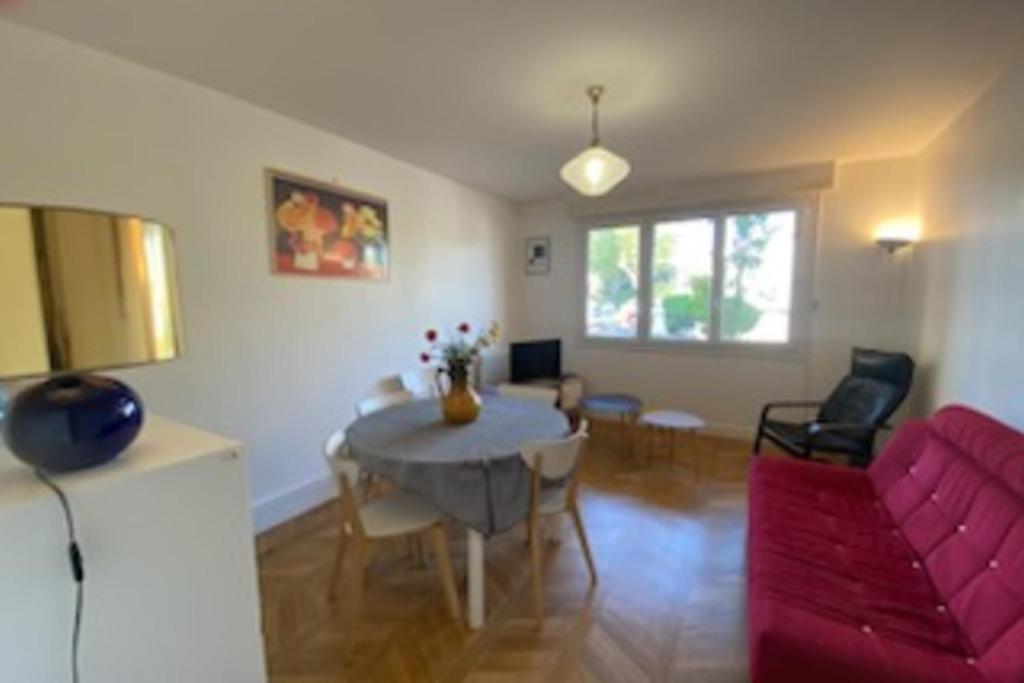 un salon avec un canapé rouge et une table dans l'établissement Lumineux 70m cosy à proximité de la plage, à Arcachon