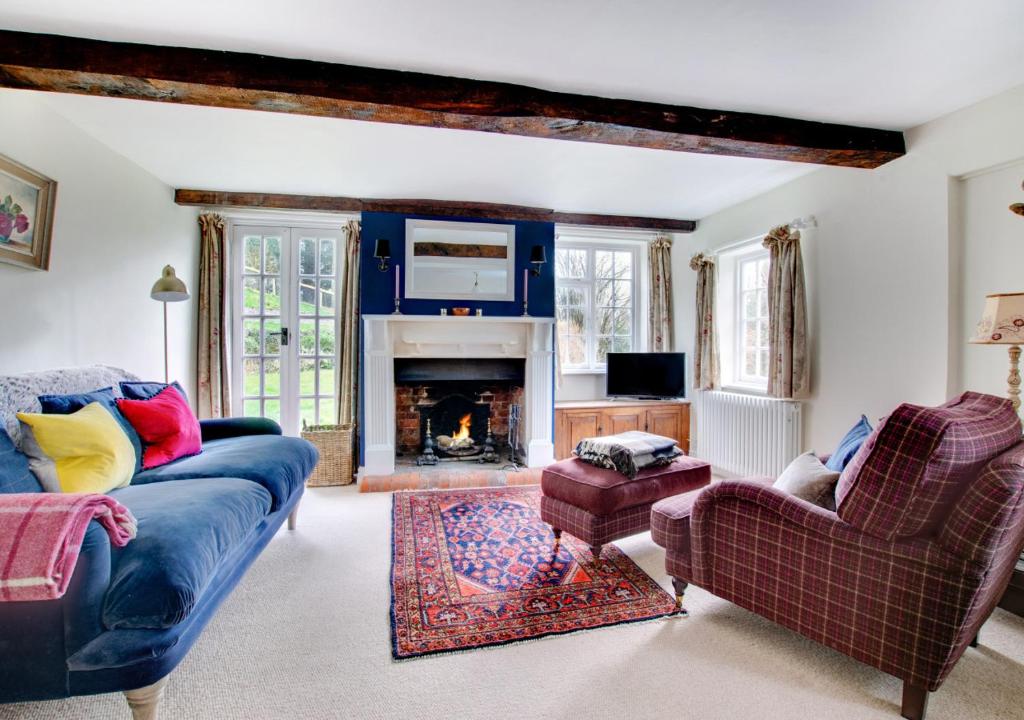 a living room with a couch and a fireplace at Mill Cottage in Ufford