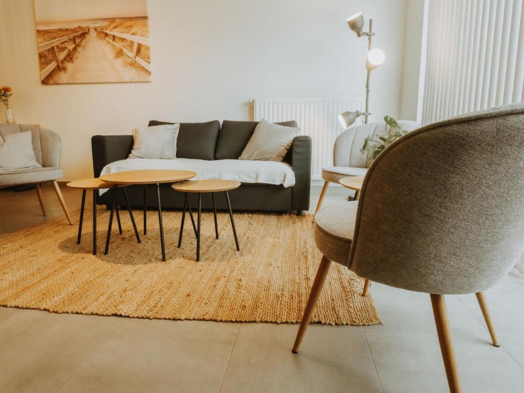 a living room with a couch and two tables at Apartment Rodenbach by Interhome in De Haan
