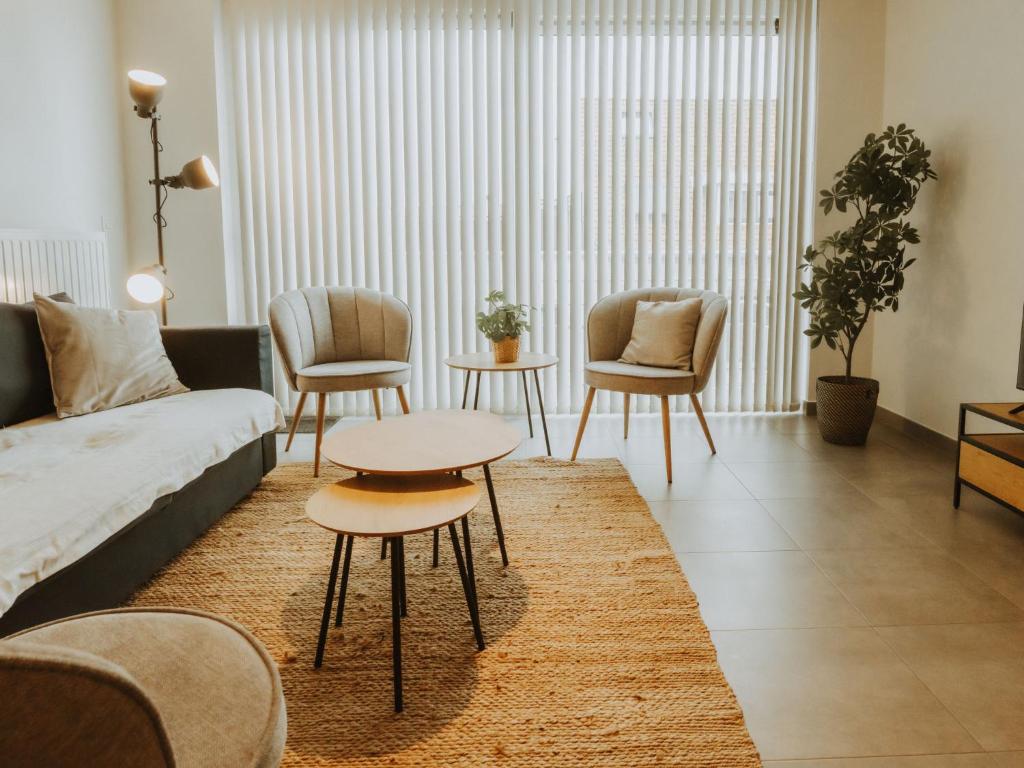 a living room with a couch and a table and chairs at Apartment Rodenbach by Interhome in De Haan