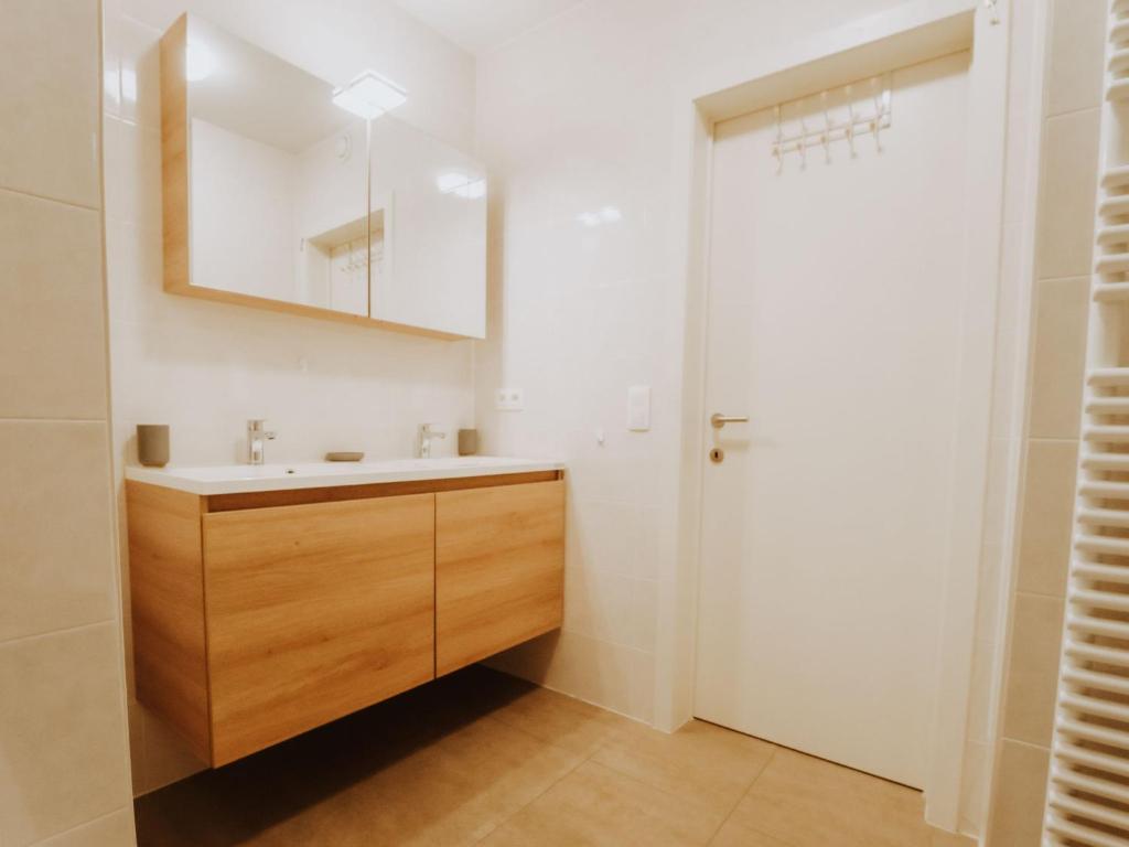 a bathroom with a sink and a mirror at Apartment Rodenbach by Interhome in De Haan