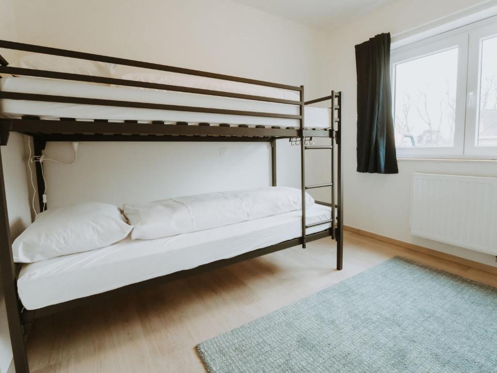 a bedroom with two bunk beds and a rug at Apartment Rodenbach by Interhome in De Haan