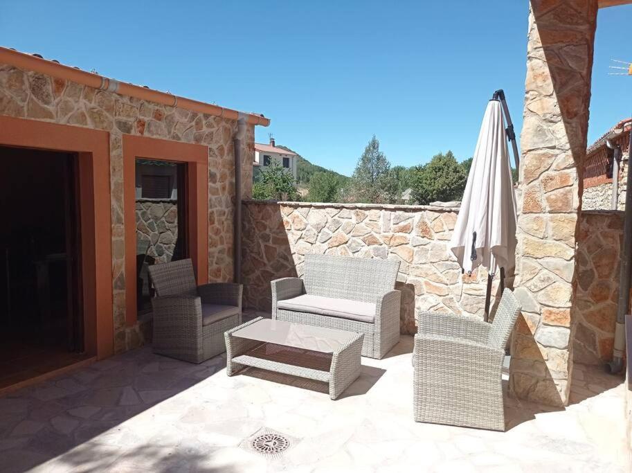un patio con sedie, un tavolo e un ombrellone di Agradable casa antigua reformada con patio a Espejón