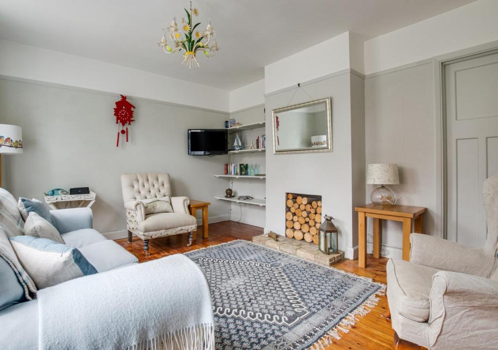 a bedroom with a bed and a couch and a fireplace at Millers Cottage in Woodbridge