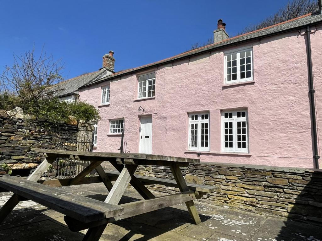 a picnic table in front of a pink building at The Brewhouse Boscastle Harbour in Boscastle