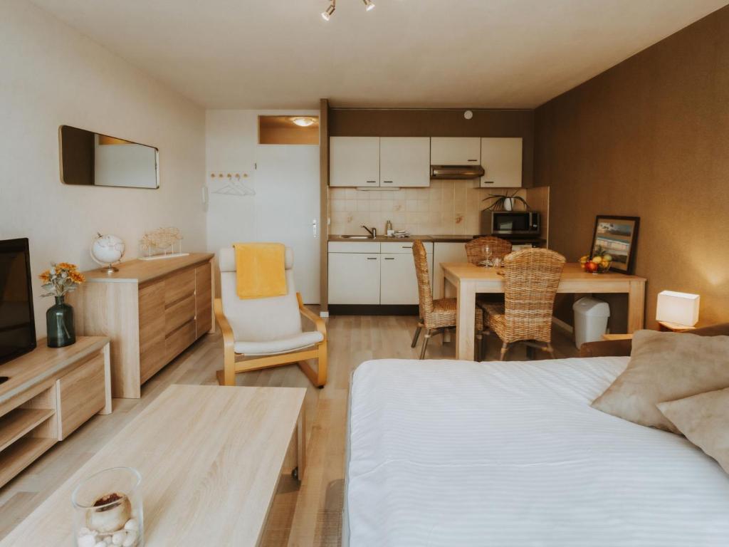 a bedroom with a bed and a kitchen with a table at Studio Zeeduin by Interhome in Bredene