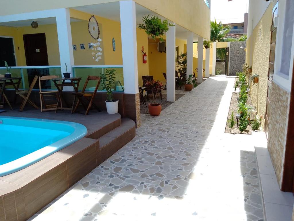 una casa con piscina e patio di Pousada Aconchego do Maraca a Porto De Galinhas