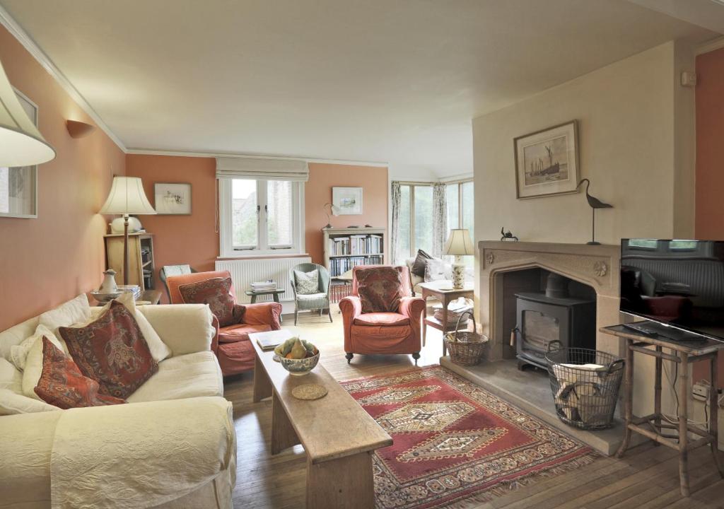 a living room with a couch and a fireplace at Old Farm in Walberswick