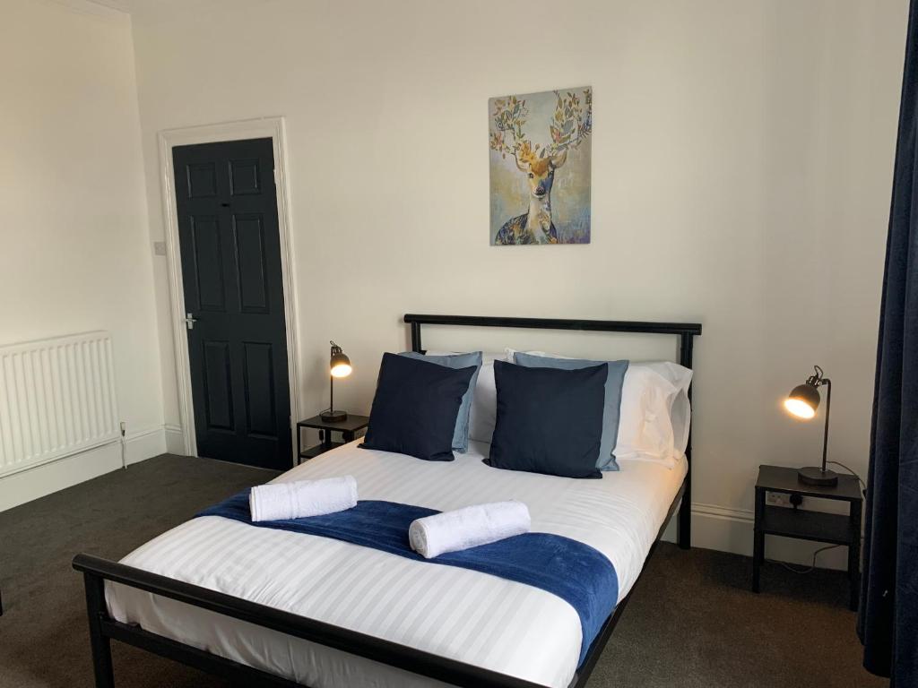 a bedroom with a large bed with blue and white pillows at Rawling - Welcoming 3 bed apartment with free Wifi and Free Parking in Gateshead