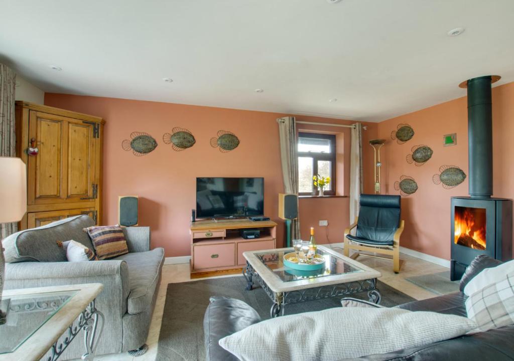 a living room with a couch and a fireplace at Owl Lodge in Ufford