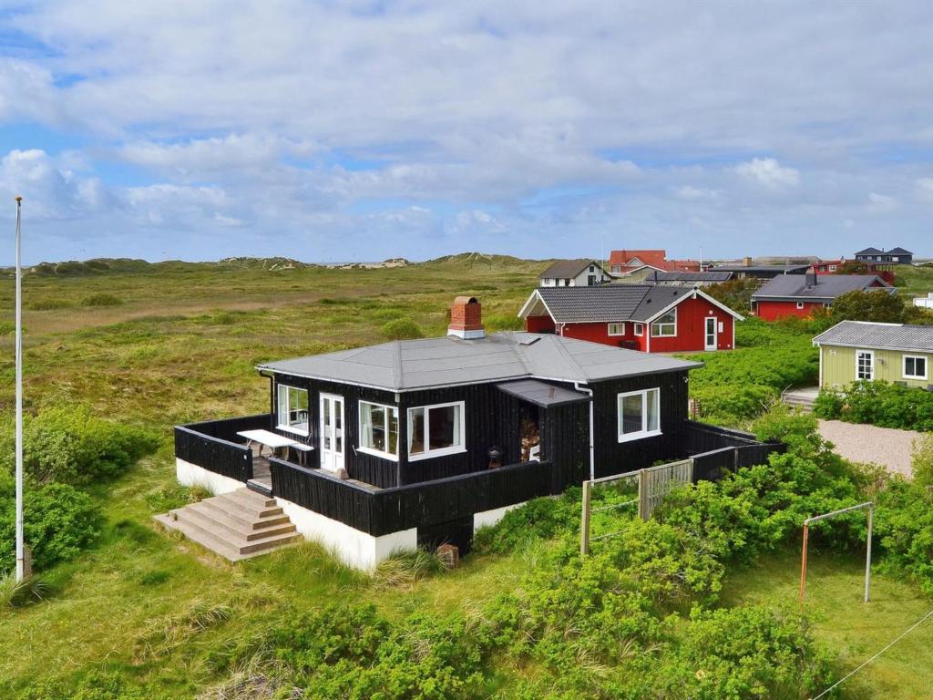 Lakolk的住宿－Holiday Home Sohvi - 450m from the sea in Western Jutland by Interhome，田野上黑屋顶的房子