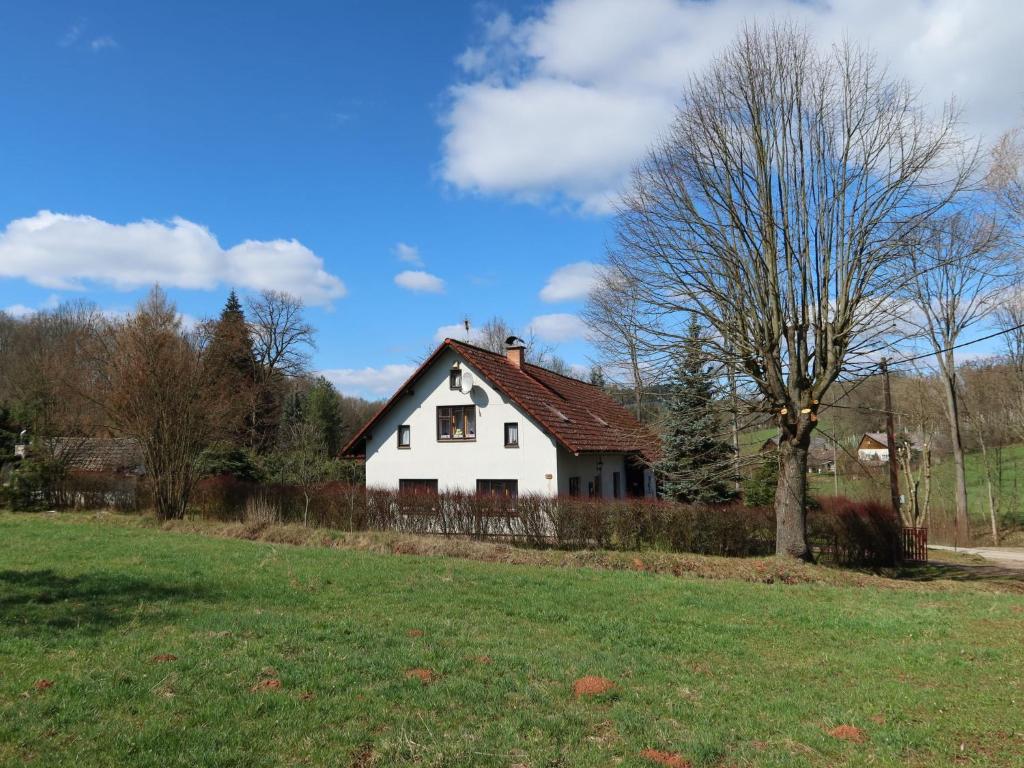 a white house with a tree in a field at Holiday Home Křečovice by Interhome in Rovensko pod Troskami