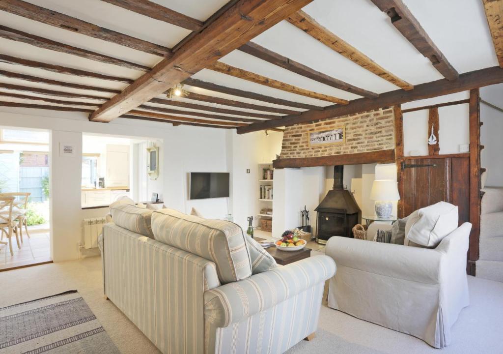 sala de estar con 2 sillas y chimenea en Oyster Cottage en Southwold