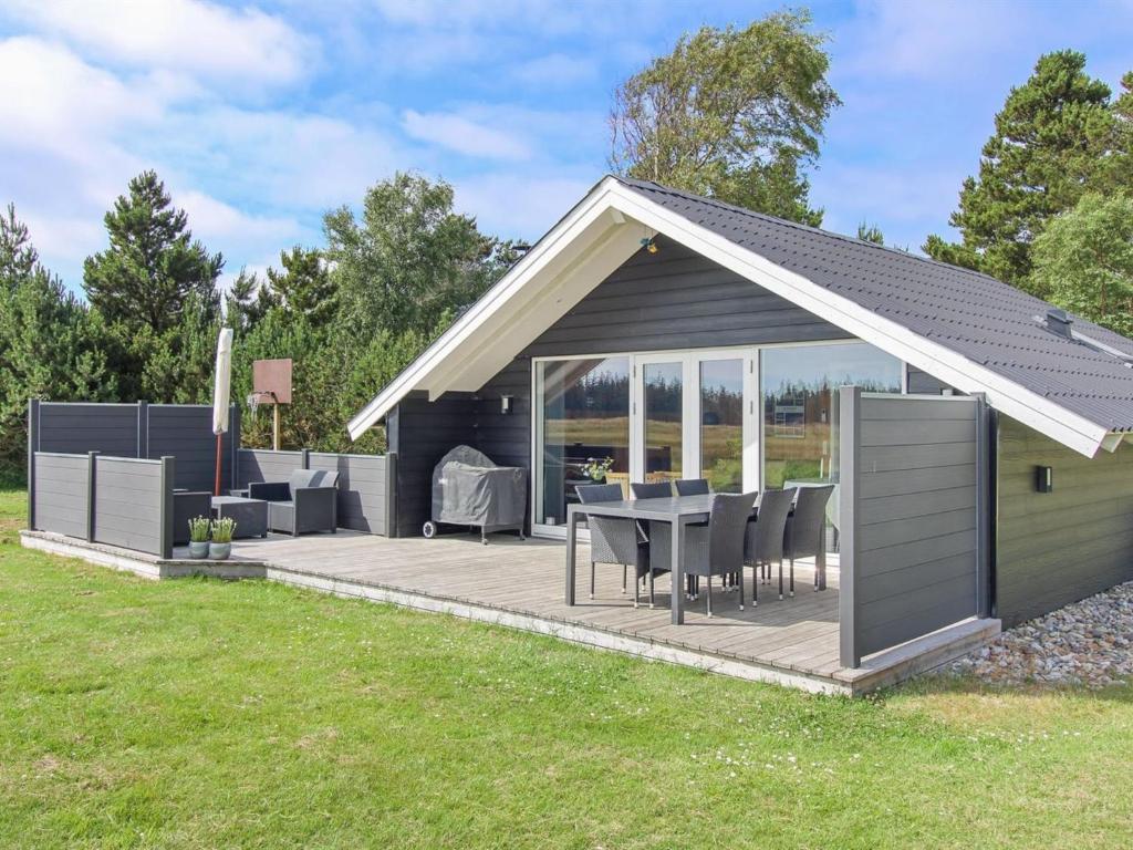 a pavilion with a table and chairs in a yard at Holiday Home Agnesa - 1-5km from the sea in Western Jutland by Interhome in Vejers Strand