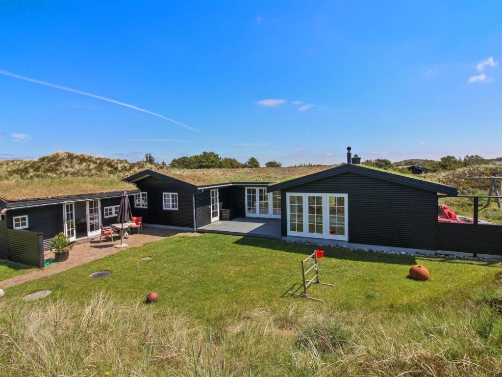 a large house with a yard with a yard at Holiday Home Ovelil - 650m from the sea in Western Jutland by Interhome in Vejers Strand