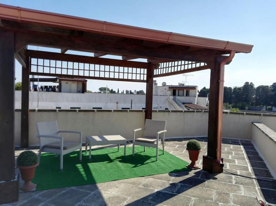 a gazebo with chairs and a table on a roof at Grazioso appartamento terrazzo e wi-fi near Otranto in Casamassella