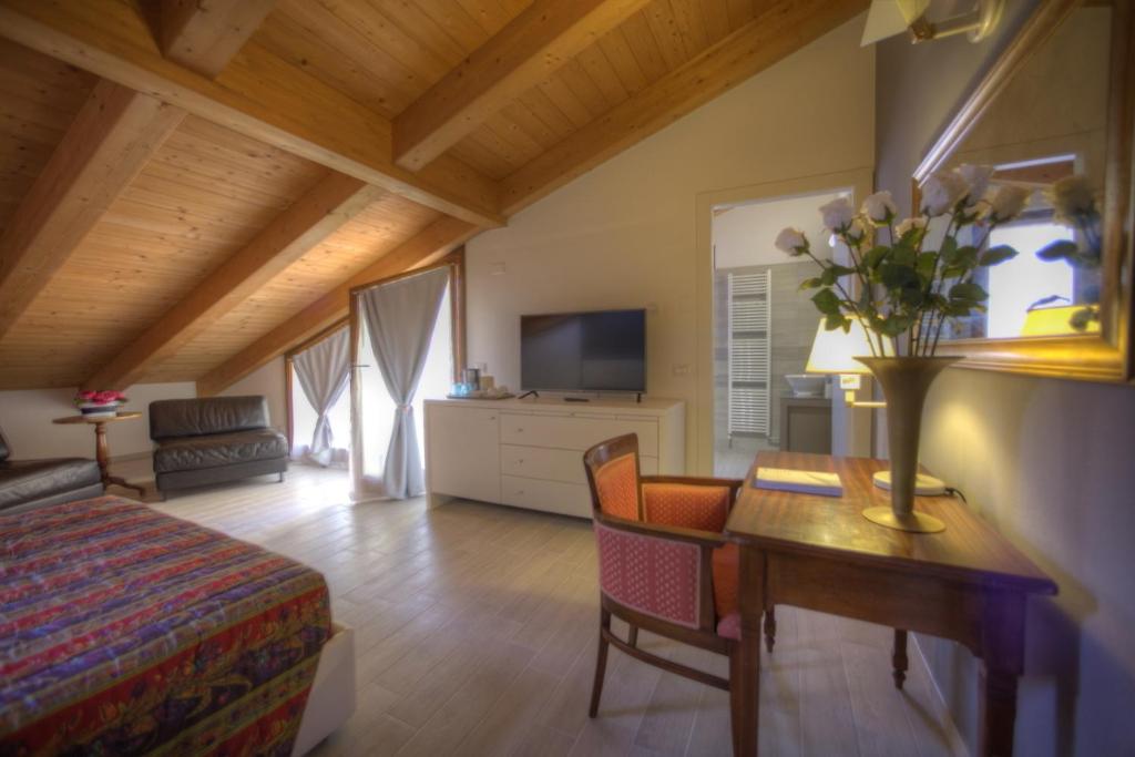 ein Schlafzimmer mit einem Bett und einem Tisch mit einer Blumenvase in der Unterkunft Holidays alle rose in Peschiera del Garda
