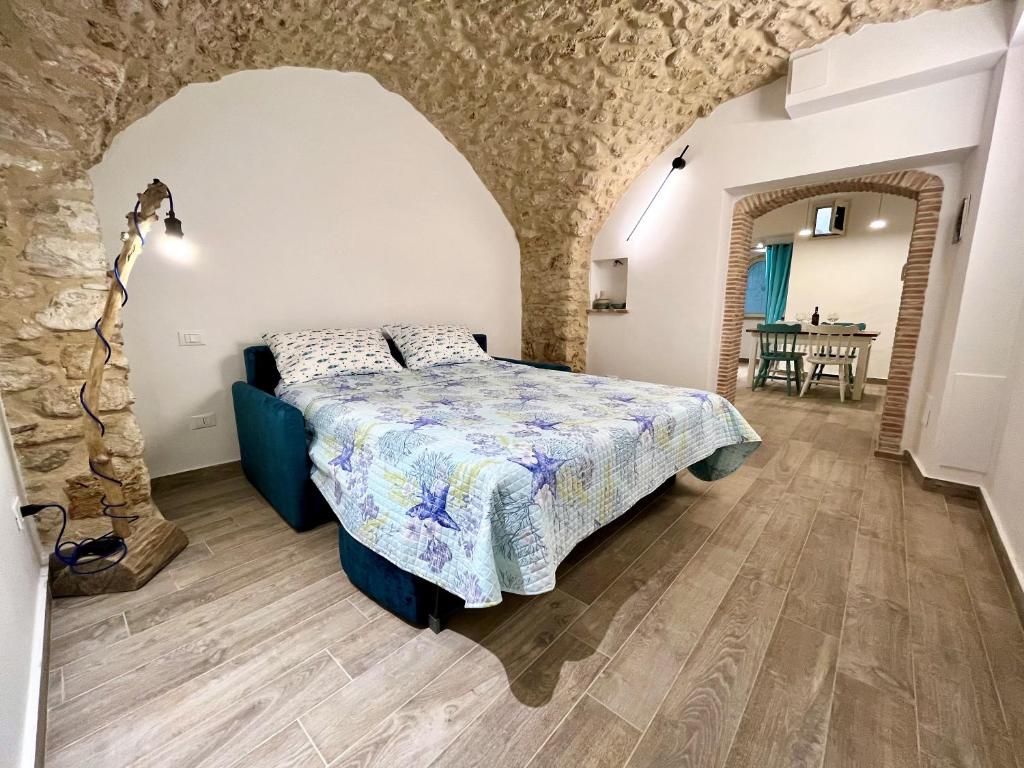 a bedroom with a bed and a stone wall at Divina Casa Vacanze Donna Filomena in Sperlonga