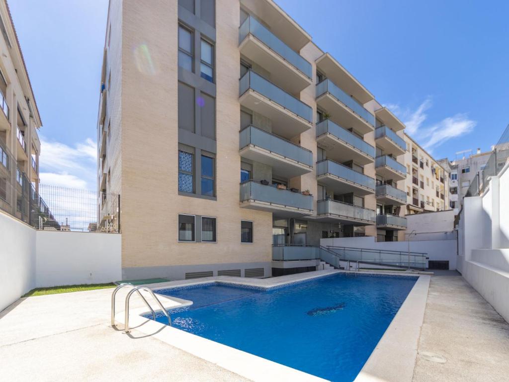 an apartment with a swimming pool in front of a building at Apartment Barcelona by Interhome in Torredembarra