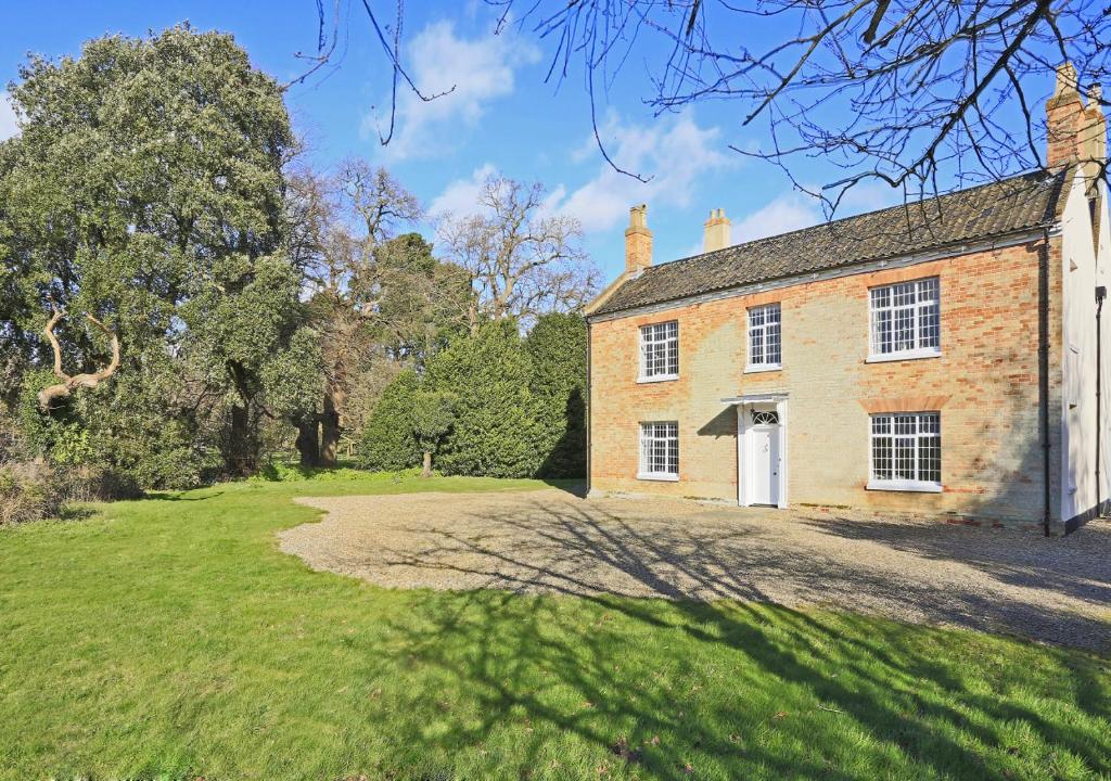 an old brick house with a large yard at Park Farm House in Wangford