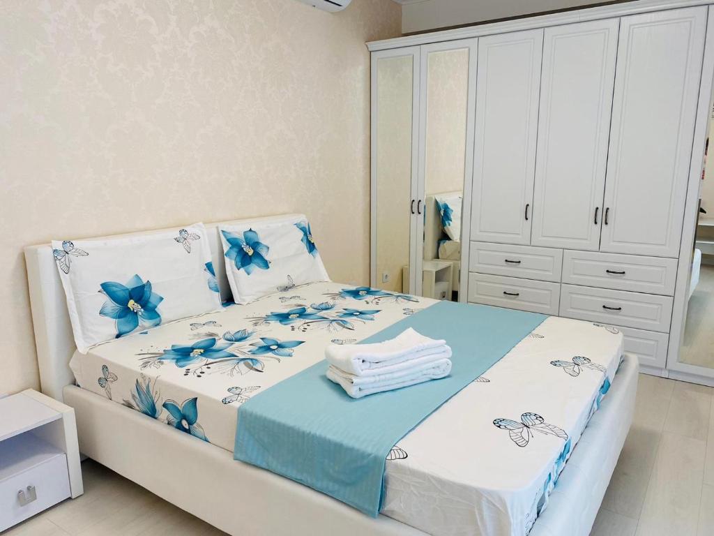 um quarto com uma cama com flores azuis em Apartament lux em Chişinău