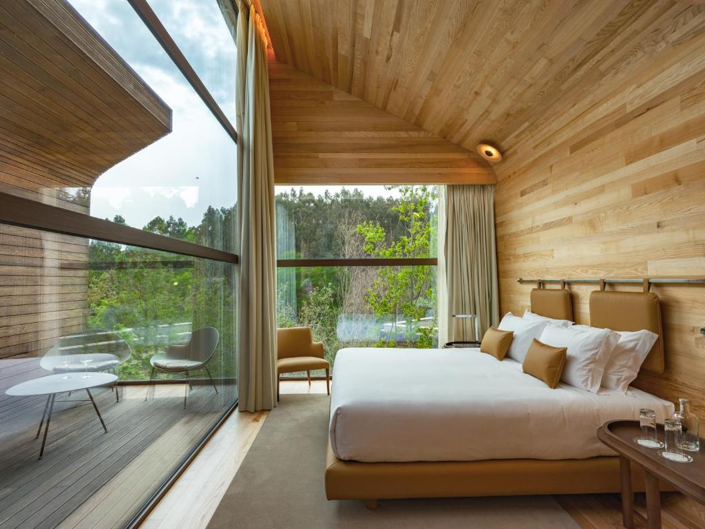 a bedroom with a large bed and a large window at Lavandeira Douro Nature & Wellness in Ancede