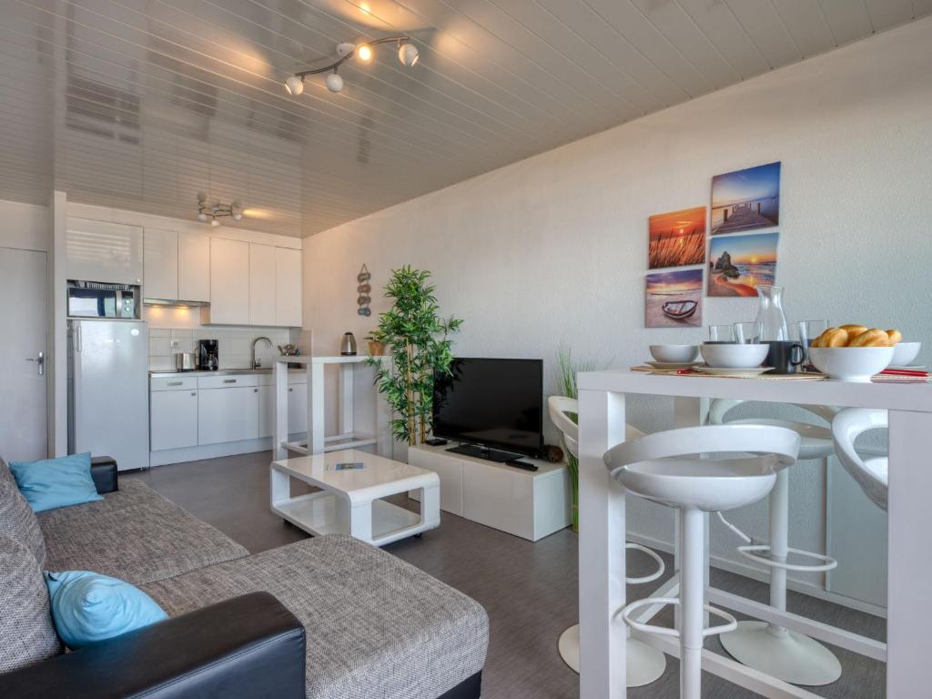 a living room with a couch and a kitchen at Apartment Les Océanides-19 by Interhome in Lacanau-Océan