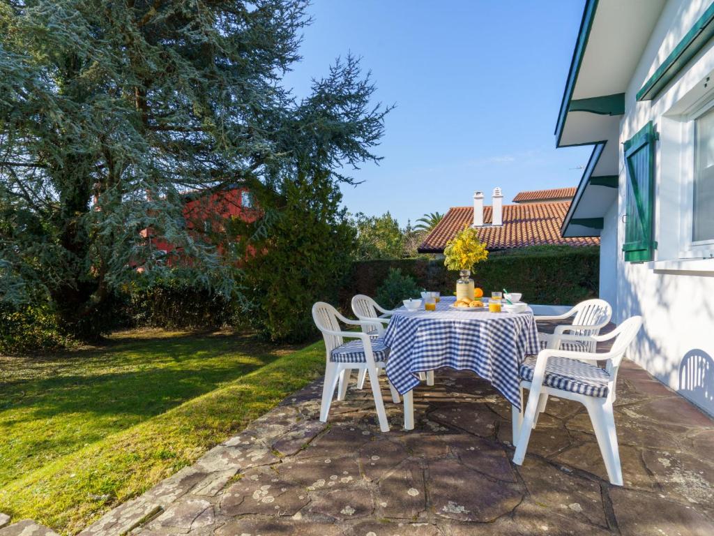 un tavolo con sedie bianche e una tovaglia blu e bianca di Holiday Home Euskara by Interhome a Saint-Jean-de-Luz