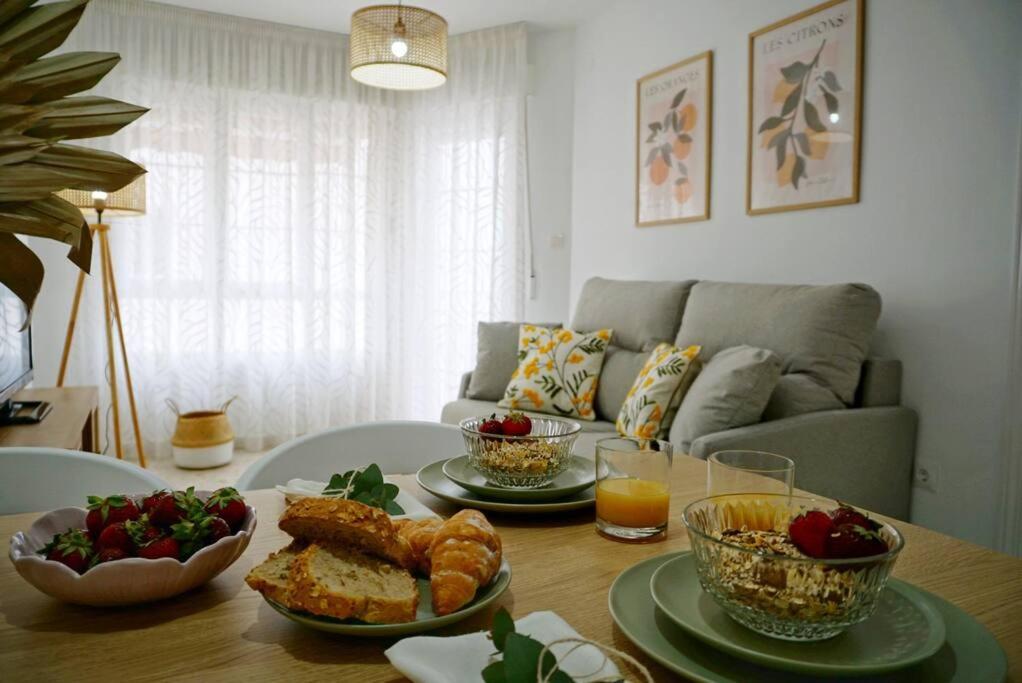 una mesa con platos de comida en la sala de estar en Apartamento El Sol Naciente, en La Herradura