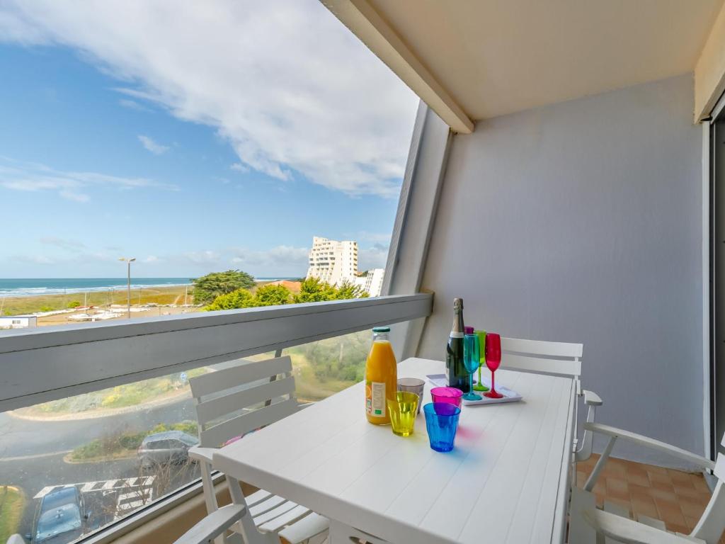 una mesa blanca con bebidas en un balcón con vistas al océano en Apartment Arc en Ciel Vue Mer by Interhome, en Les Bains