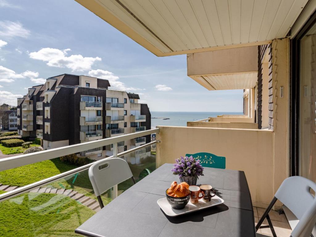 a table on a balcony with a view of the ocean at Apartment Le Domaine des roches by Interhome in Trouville-sur-Mer