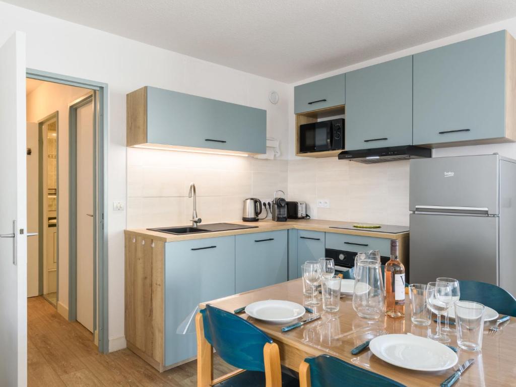 una cucina con tavolo, piatti e bicchieri da vino di Apartment Port Arcachon-5 by Interhome ad Arcachon