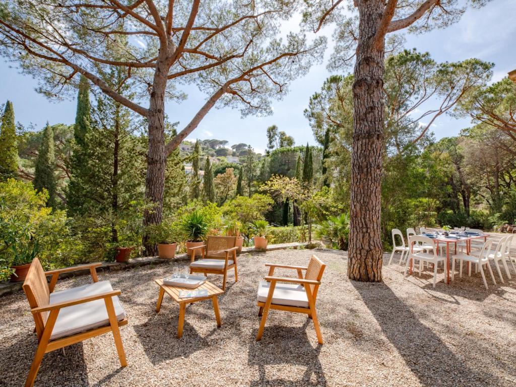 un patio avec des tables et des chaises sous un arbre dans l'établissement Holiday Home Les Agasses by Interhome, à Sainte-Maxime