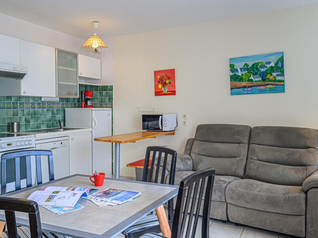salon z kanapą i stołem z krzesłami w obiekcie Apartment Le Galion by Interhome w mieście Trinité-sur-Mer
