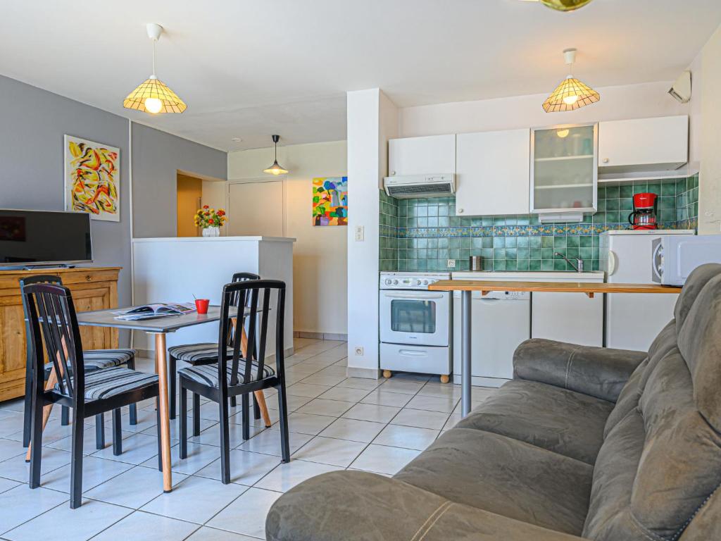 salon i kuchnia z kanapą i stołem w obiekcie Apartment Le Galion by Interhome w mieście Trinité-sur-Mer