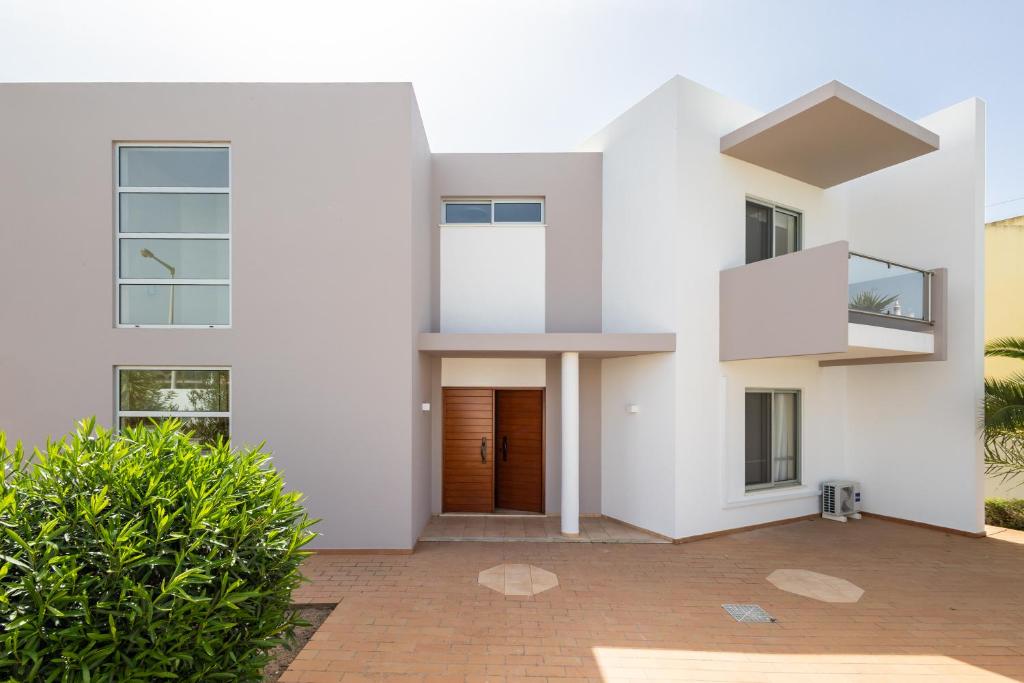 a white house with a wooden door at Marachique Villa - Torralvor in Alvor