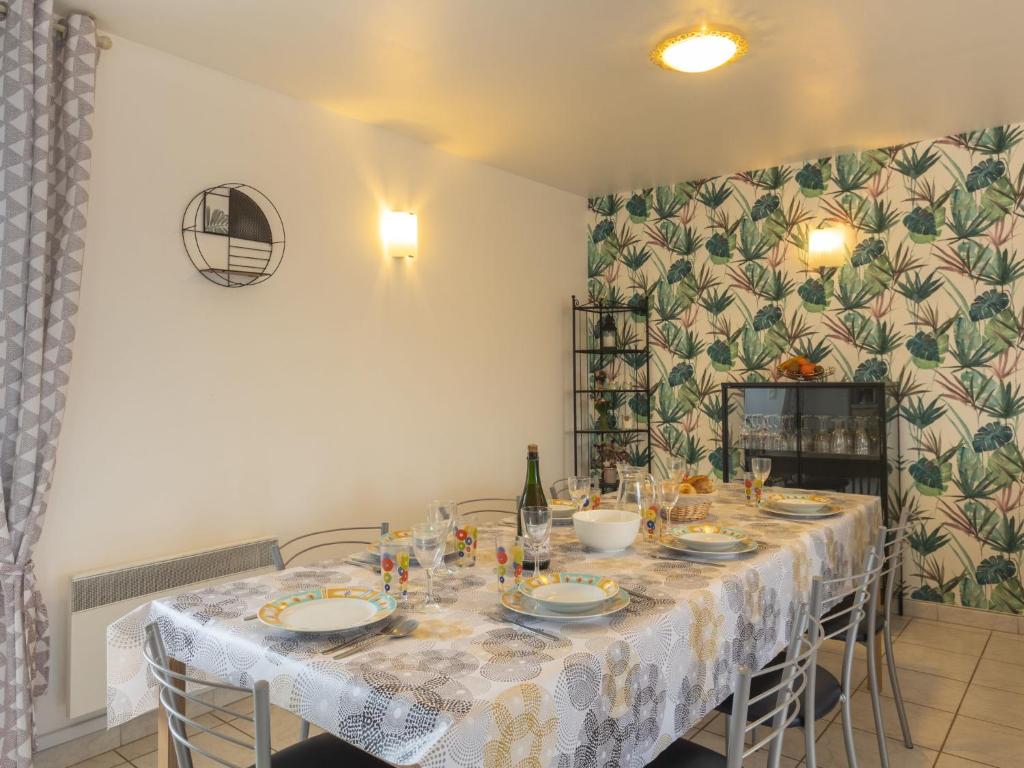 a dining room with a table with a white table cloth at Holiday Home Coquelicot by Interhome in Saint-Méloir-des-Ondes