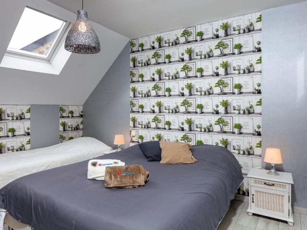 a bedroom with a bed and a wall of potted plants at Holiday Home Coquelicot by Interhome in Saint-Méloir-des-Ondes
