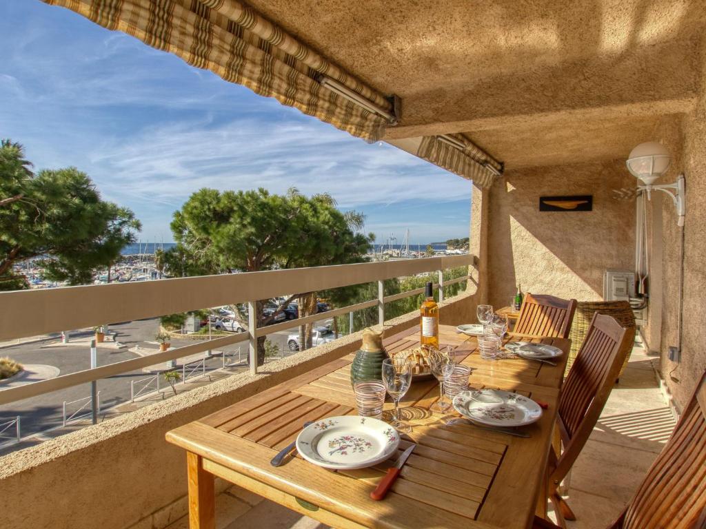 - une table en bois sur le balcon d'une maison dans l'établissement Apartment Le port des lecques by Interhome, à Saint-Cyr-sur-Mer