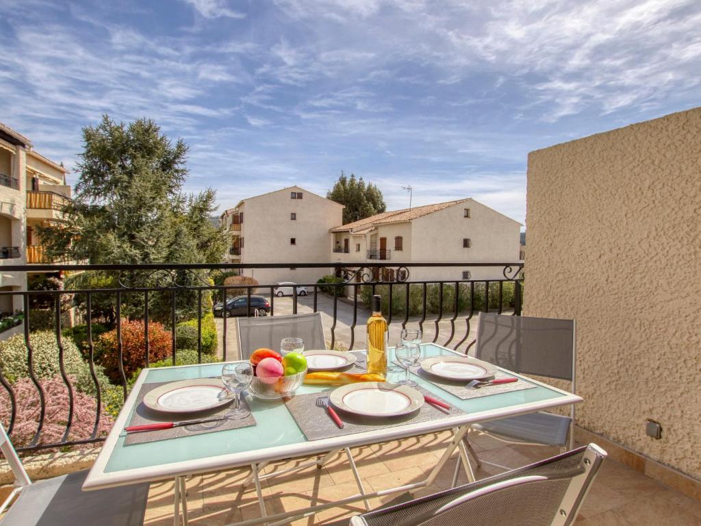 une table avec des assiettes de nourriture sur un balcon dans l'établissement Apartment Provence Village-5 by Interhome, à Saint-Cyr-sur-Mer