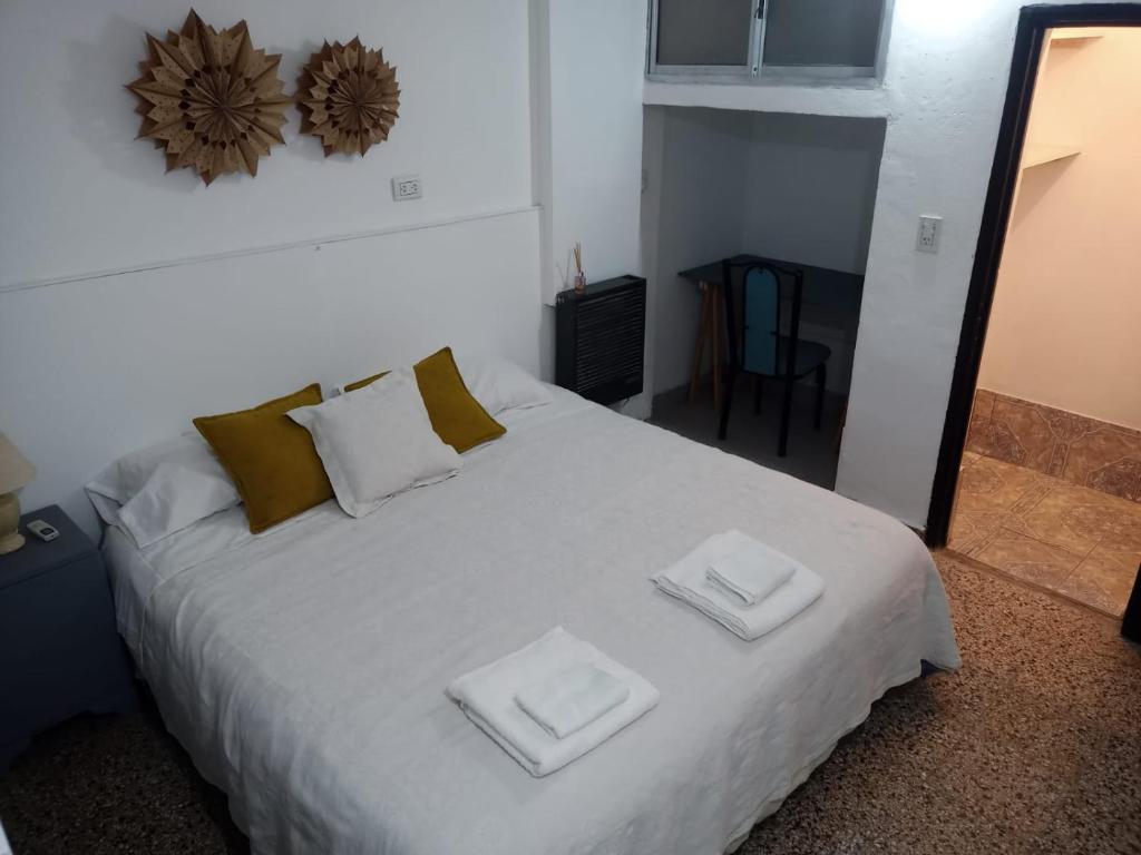 1 dormitorio con 1 cama blanca y 2 toallas en Cacique Catriel "EN PLANTA BAJA" en Catriel