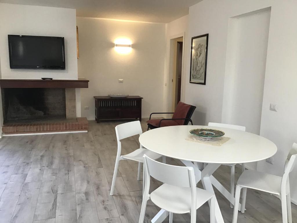 een woonkamer met een witte tafel en stoelen en een tv bij Il Parco IUN R1207 - Ingresso indipendente con quattro posti letto in Santa Giusta