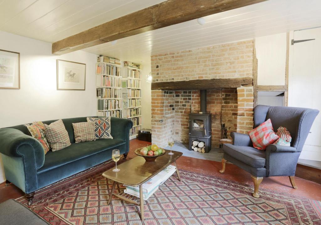 a living room with two couches and a fireplace at Sherfield Cottage in Snape